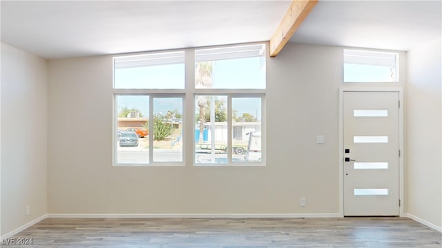 foyer featuring light hardwood / wood-style floors and lofted ceiling with beams