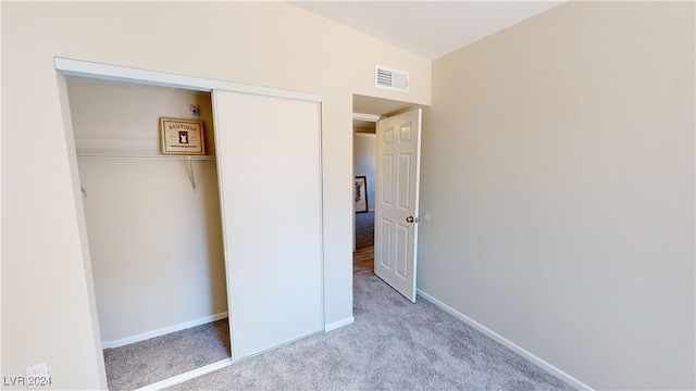 unfurnished bedroom with light carpet and a closet