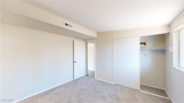 unfurnished bedroom with a closet and light carpet