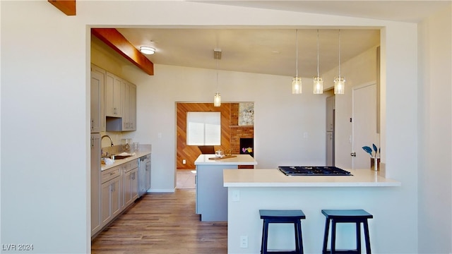 kitchen with hanging light fixtures, light hardwood / wood-style flooring, lofted ceiling, kitchen peninsula, and a breakfast bar area