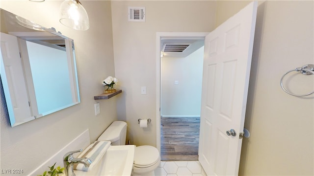 bathroom with toilet and hardwood / wood-style flooring