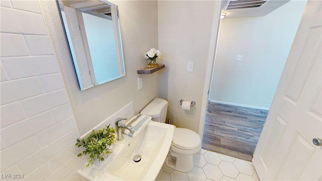 bathroom with toilet, hardwood / wood-style flooring, and sink