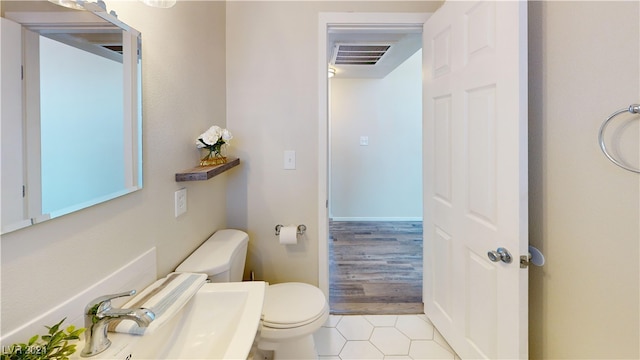 bathroom featuring toilet, hardwood / wood-style flooring, and sink