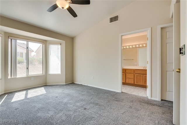 unfurnished bedroom with ceiling fan, connected bathroom, light carpet, and vaulted ceiling