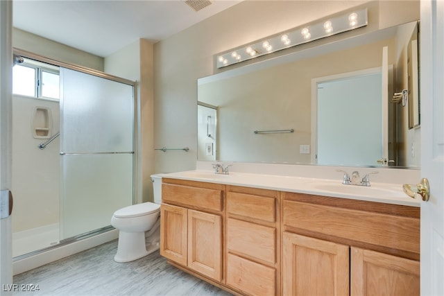 bathroom featuring vanity, toilet, hardwood / wood-style flooring, and walk in shower