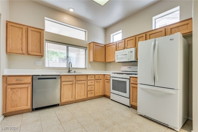 kitchen with white appliances, a healthy amount of sunlight, and sink