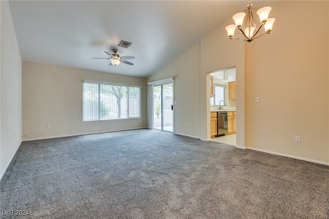 unfurnished living room featuring vaulted ceiling, sink, ceiling fan with notable chandelier, and light carpet