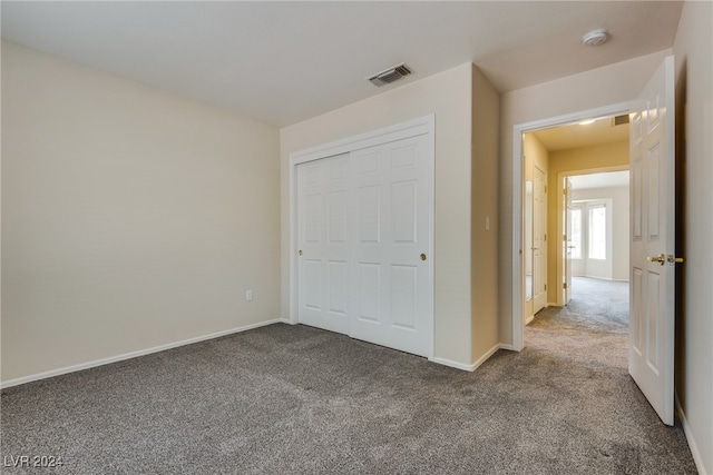 unfurnished bedroom with carpet and a closet