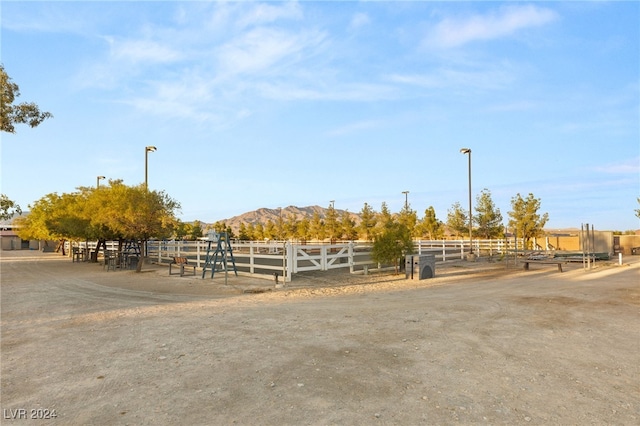 view of horse barn featuring a mountain view and a rural view