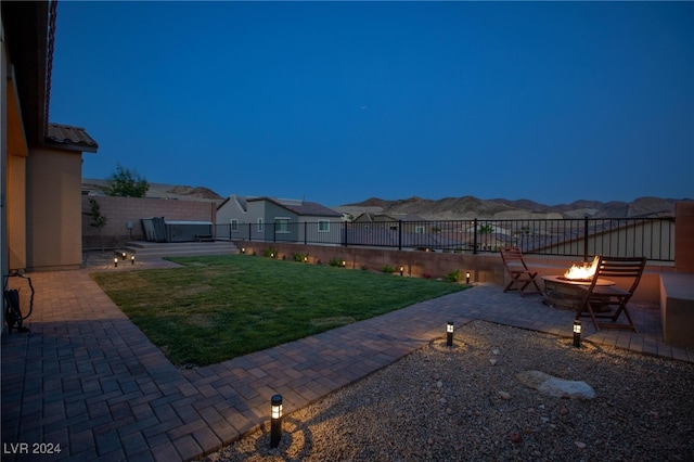 view of yard with a mountain view, a patio, and an outdoor fire pit