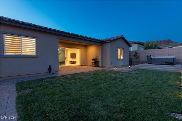 rear view of house featuring a patio and a lawn