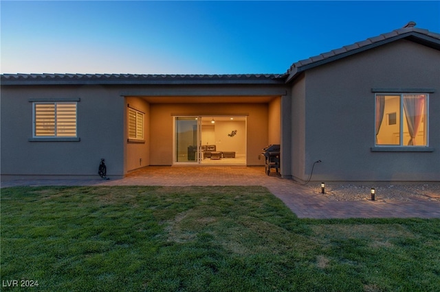 rear view of property featuring a patio and a lawn