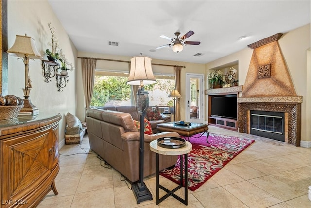 living room with ceiling fan, a fireplace, and light tile patterned flooring