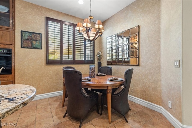 dining space with light tile patterned floors and an inviting chandelier