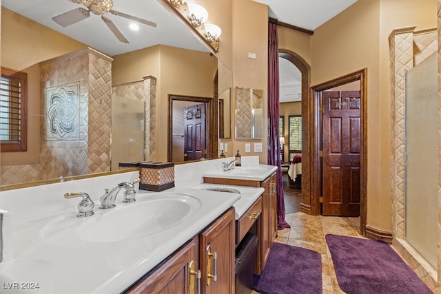 bathroom featuring ceiling fan, a tile shower, and vanity