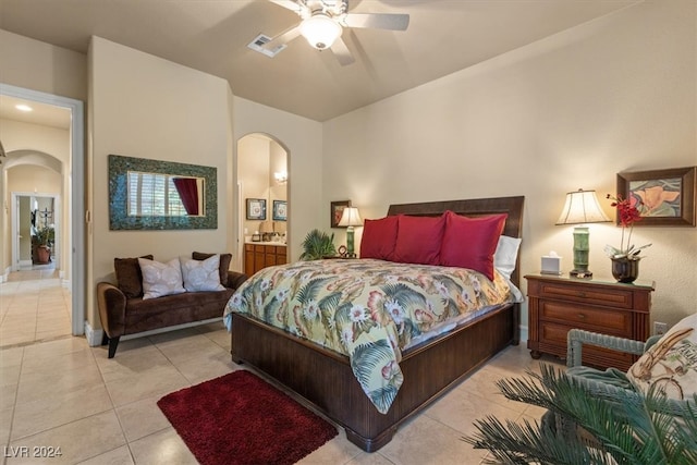 tiled bedroom featuring ceiling fan and ensuite bath