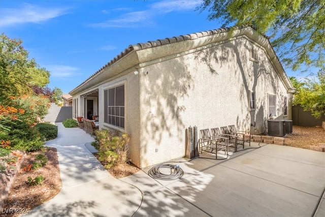 view of home's exterior featuring cooling unit and a patio