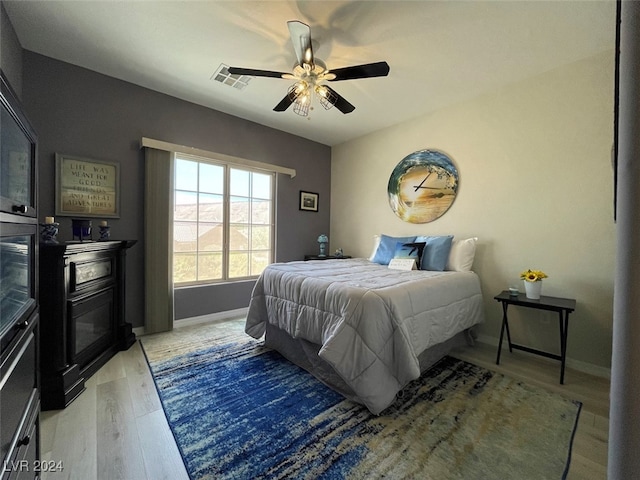 bedroom with ceiling fan and light hardwood / wood-style floors