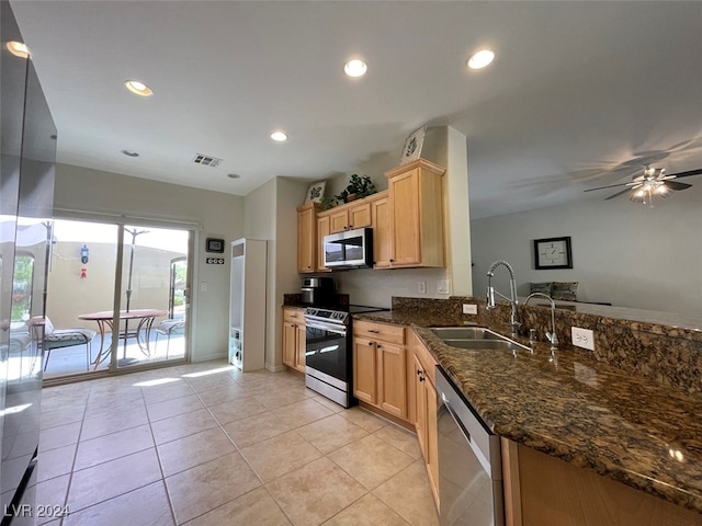 kitchen featuring dark stone counters, stainless steel appliances, kitchen peninsula, sink, and ceiling fan