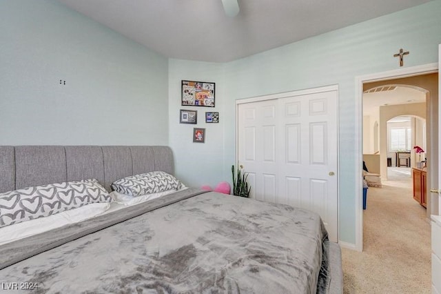 carpeted bedroom with ceiling fan and a closet