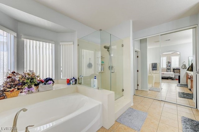 bathroom with a wealth of natural light, independent shower and bath, and tile patterned flooring