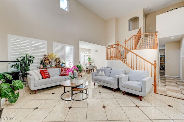 living room featuring a high ceiling, an inviting chandelier, and light tile patterned floors