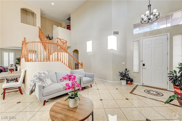 tiled entryway with a high ceiling and a chandelier