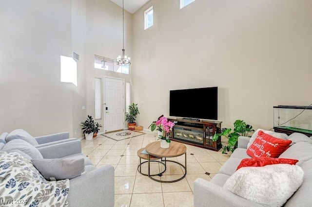 tiled living room featuring a towering ceiling and a notable chandelier