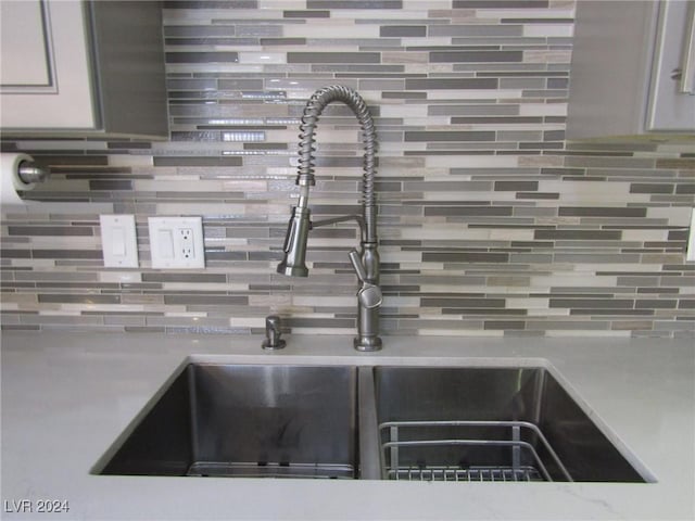 interior details featuring sink and decorative backsplash