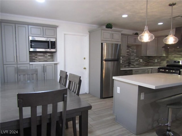 kitchen featuring stainless steel appliances, sink, pendant lighting, and backsplash