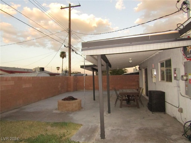 patio terrace at dusk featuring a fire pit