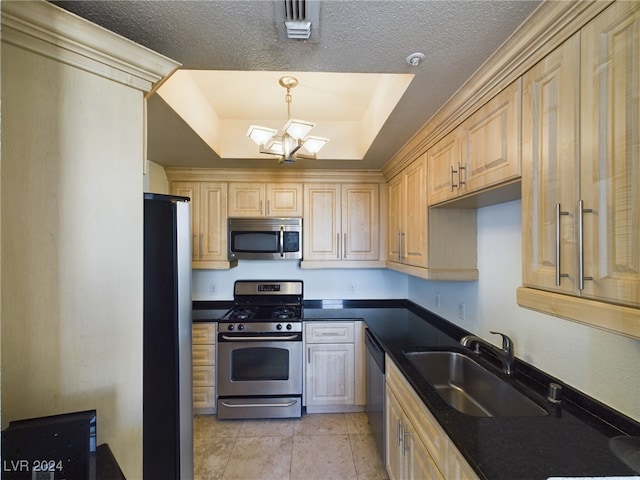 kitchen with light tile patterned floors, an inviting chandelier, appliances with stainless steel finishes, sink, and a raised ceiling