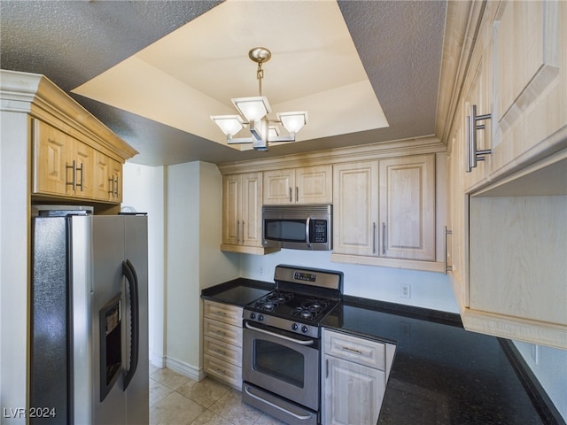 kitchen featuring light brown cabinetry, light tile patterned floors, appliances with stainless steel finishes, a notable chandelier, and a raised ceiling