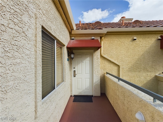 view of exterior entry with a balcony