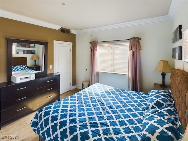 bedroom featuring light hardwood / wood-style flooring and ornamental molding