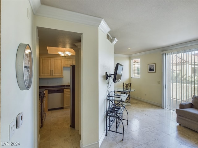 hall with a textured ceiling, crown molding, a notable chandelier, and light tile patterned floors