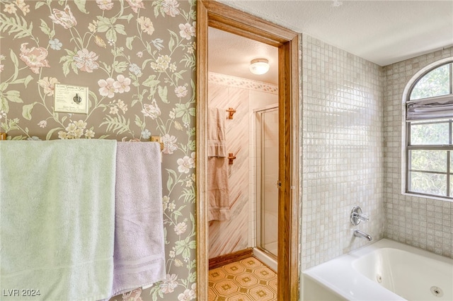 full bath with a stall shower, a textured ceiling, and wallpapered walls