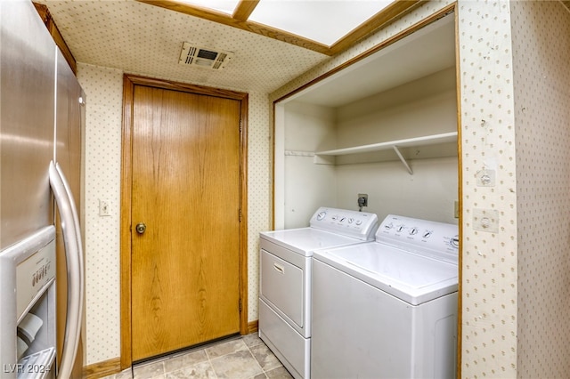 clothes washing area featuring laundry area, visible vents, wallpapered walls, and independent washer and dryer