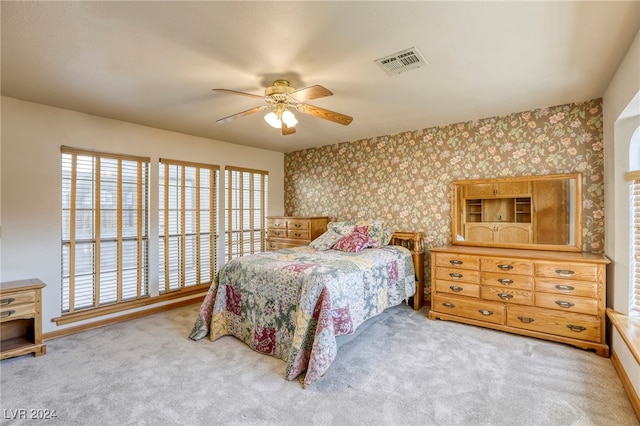 bedroom featuring visible vents, light carpet, and wallpapered walls