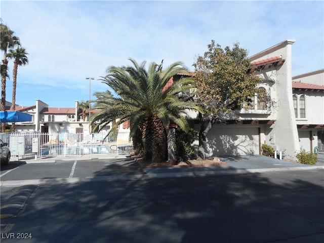 view of front of house featuring driveway, fence, and stucco siding