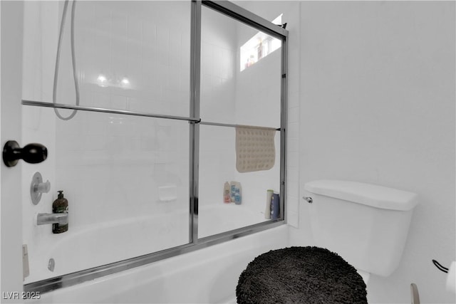 bathroom with bath / shower combo with glass door and toilet