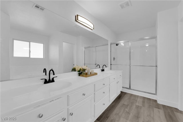 bathroom featuring vanity, hardwood / wood-style floors, and a shower with shower door