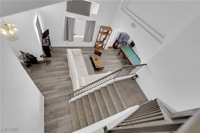 stairway with an inviting chandelier and wood-type flooring