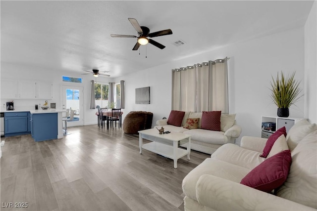 living room featuring ceiling fan and light hardwood / wood-style floors