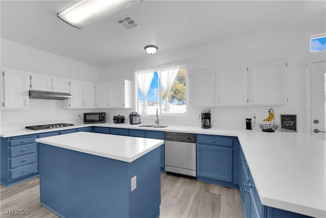 kitchen with sink, appliances with stainless steel finishes, a center island, white cabinets, and blue cabinets