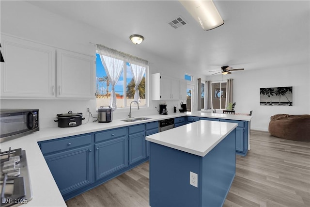 kitchen featuring blue cabinets, sink, a kitchen island, and white cabinets