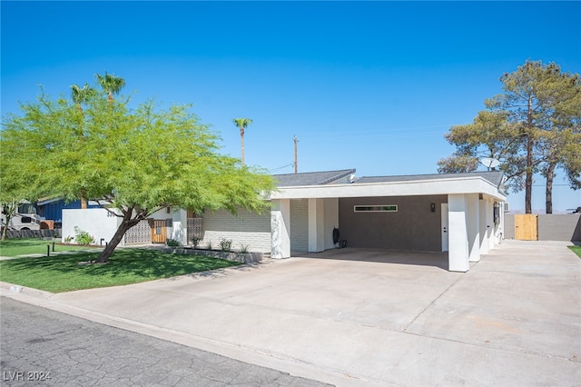 view of front of property featuring a carport and a front lawn