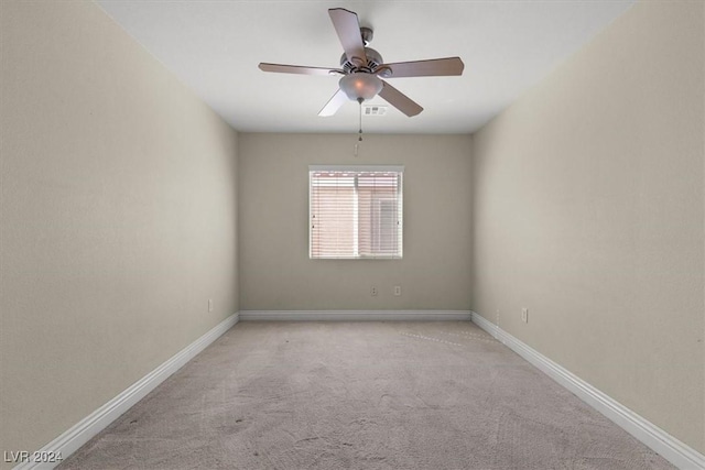 empty room with carpet flooring, ceiling fan, visible vents, and baseboards