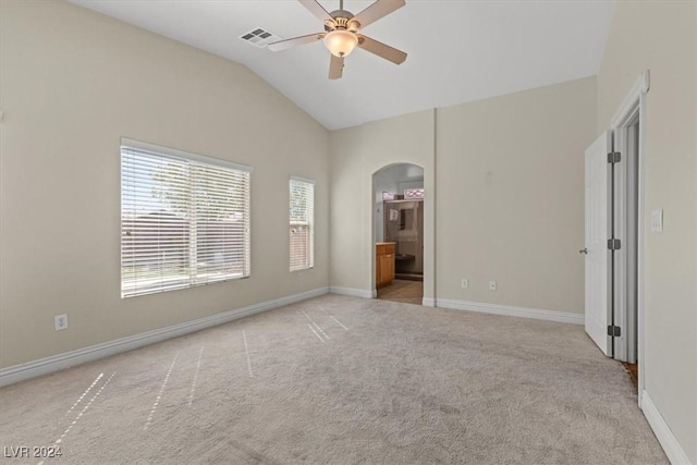 unfurnished bedroom featuring visible vents, arched walkways, baseboards, lofted ceiling, and carpet