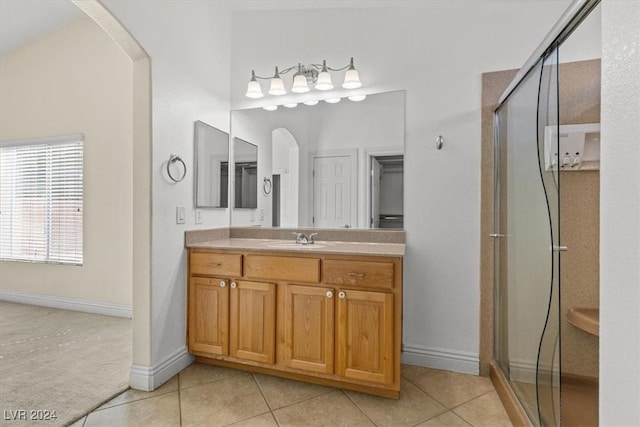 full bath with a stall shower, vanity, baseboards, and tile patterned floors